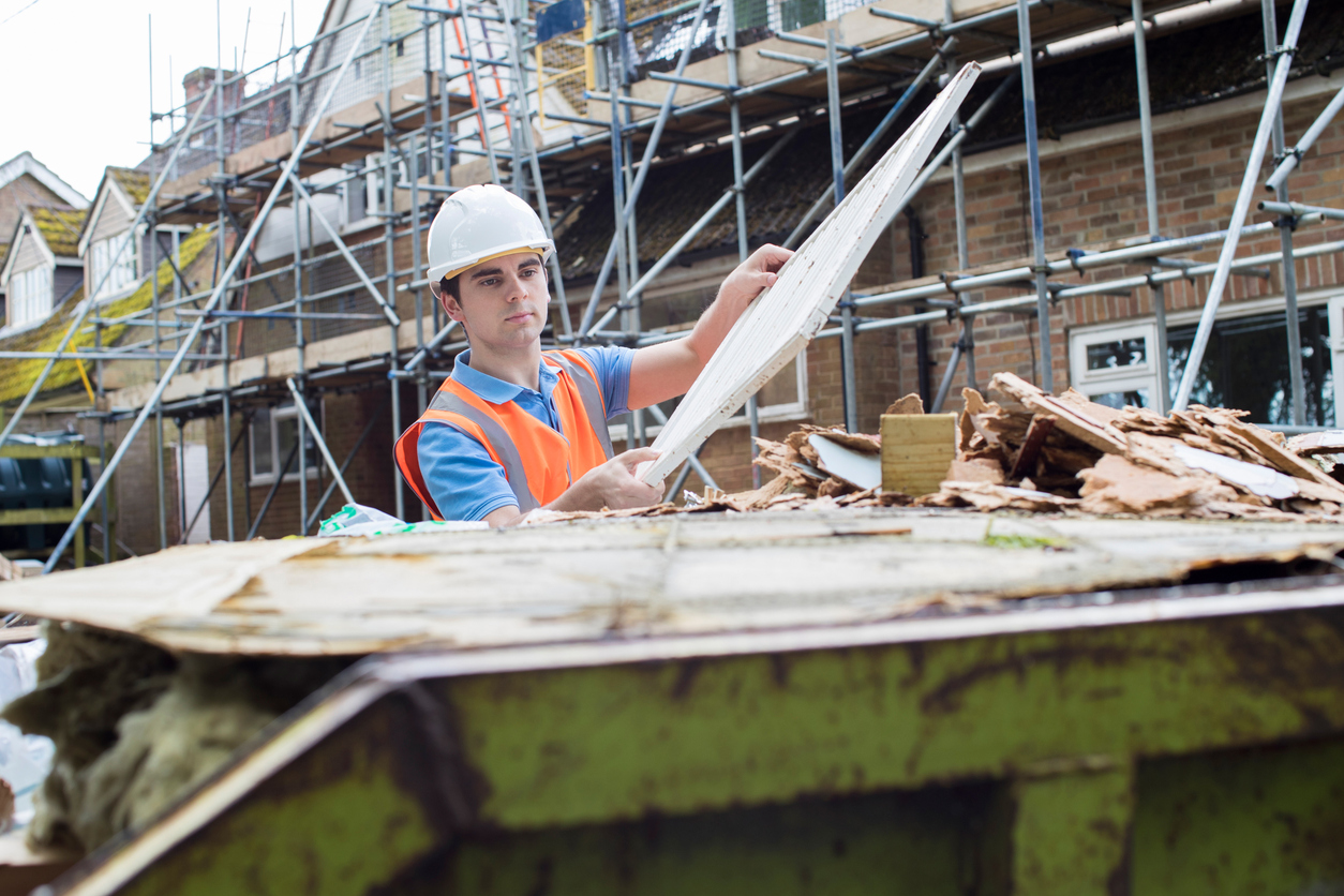 Man putting waste in skip